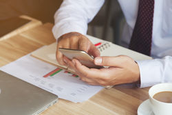 stock-photo-side-view-of-a-businessman-using-a-telephone-contact-to-verify-and-validate-the-customer-after-721307086